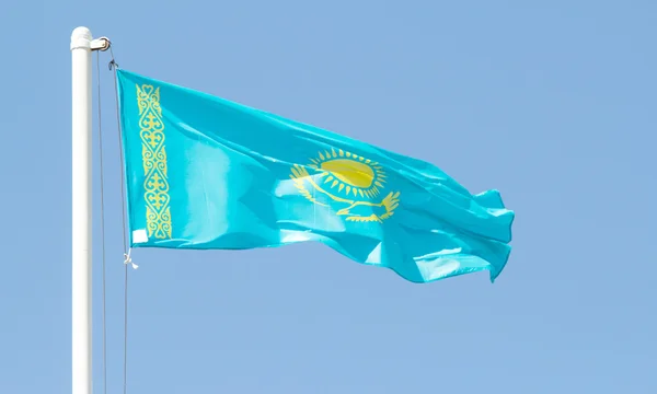 Cazaquistão agitando bandeira contra o céu azul — Fotografia de Stock