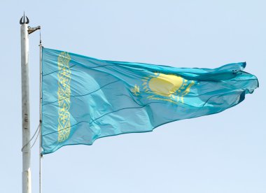 Mavi gökyüzü karşı bayrak sallayarak Kazakistan