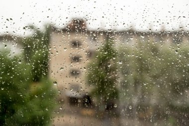 Bir pencere bölmesinde yağmur damlaları