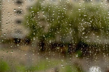 Bir pencere bölmesinde yağmur damlaları