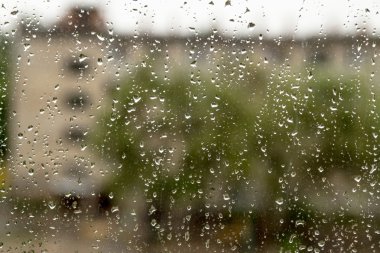 Bir pencere bölmesinde yağmur damlaları,