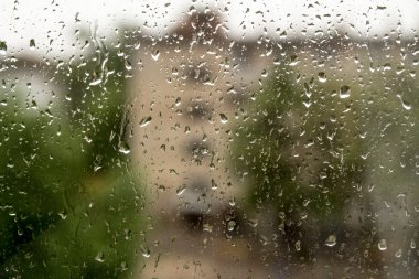 Bir pencere bölmesinde yağmur damlaları,