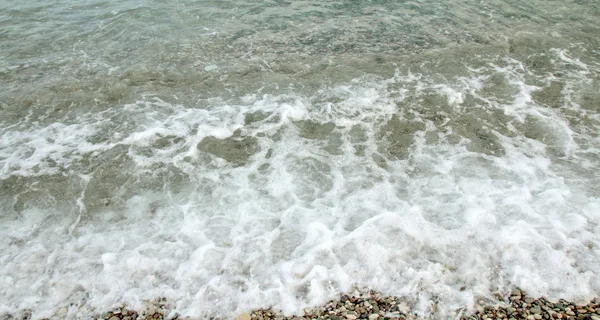 Espuma de olas marinas en la playa . — Foto de Stock