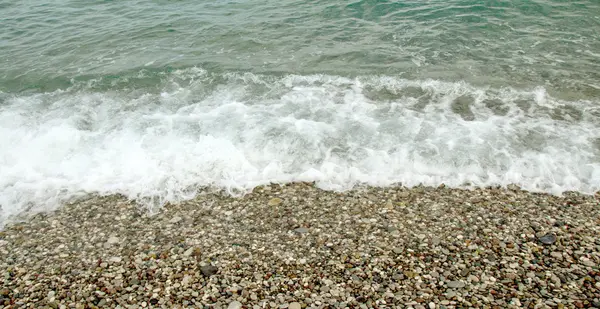 Wave skum på stranden. — Stockfoto