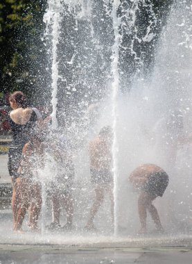Petropavlovsk, Kazakistan - 18 Temmuz 2024: Çocuklar yaz sıcağında çeşmede serinleyebilir. Çocukları serinletmek için eğlenceli ve ferahlatıcı bir yol. Yaz tatili.