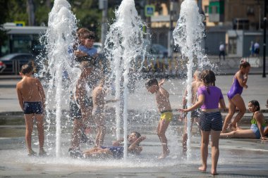 Petropavlovsk, Kazakistan - 18 Temmuz 2024: Çocuklar yaz sıcağında çeşmede serinleyebilir. Çocukları serinletmek için eğlenceli ve ferahlatıcı bir yol. Yaz tatili.