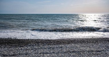 Seashore, small stones, sea wave. Marine background.