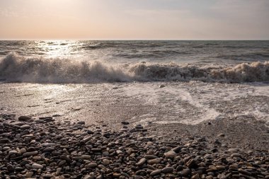 Seashore, small stones, sea wave. Marine background.