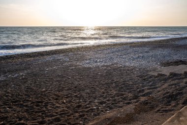 Seashore, small stones, sea wave. Marine background.