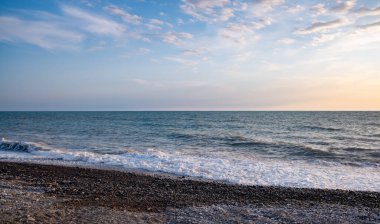 Seashore, small stones, sea wave. Marine background.