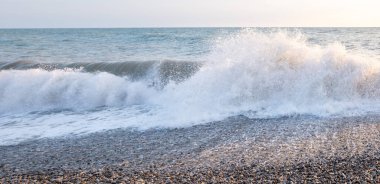 Seashore, small stones, sea wave. Marine background.