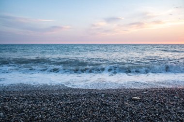 Seashore, small stones, sea wave. Marine background.