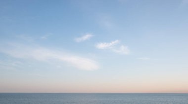Blue sea and blue sky with white clouds. Seascape.