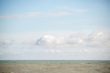 Blue sea and blue sky with white clouds. Seascape.
