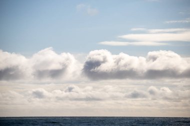 Blue sea and blue sky with white clouds. Seascape.