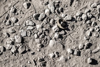 Ortasında küçük bir delik olan kayalık bir bölge. Çukur kayalar ve toprakla çevrili.