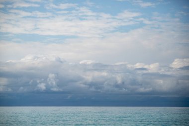 Blue sea and blue sky with white clouds. Seascape.