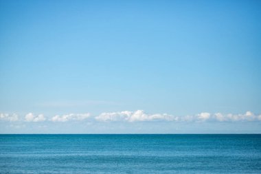 Blue sea and blue sky with white clouds. Seascape.