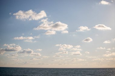 Blue sea and blue sky with white clouds. Seascape.
