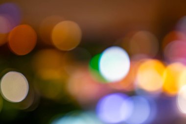 The image is a blurry, colorful, and abstract representation of a cityscape. The various colors and shapes of the circles create a sense of movement and energy, as if the city is constantly in motion