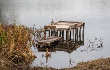 Etrafında birkaç yabani ot büyüyen bir rıhtım var. Rıhtım eski ve paslı, su da bulanık. Sahne terk edilmişlik ve ihmalkarlık hissi veriyor.