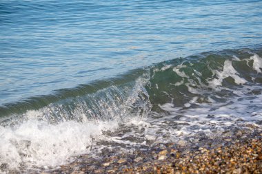 A sea wave breaks against the rocks, water splashes in the sky. Tidal wave.