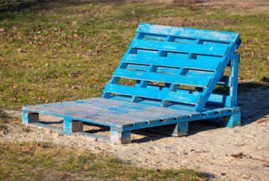 Yerde mavi bir ahşap tahta var. Kullanılmayan bir mobilya parçası.