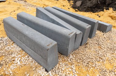 A pile of gray bricks with the letters N, M, W, and V on them. The bricks are stacked in a way that they spell out the word 