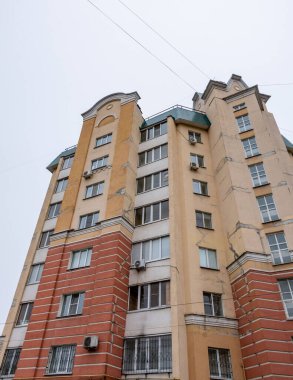 Kırmızı tuğlalı ve beyaz pencereli uzun bir bina. Bina boş ve görünürde kimse yok.