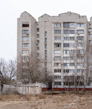 Bir sürü penceresi olan büyük bir tuğla bina. Bina eski ve bir sürü çatlağı var.