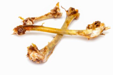 Bir sürü etle kaplı iki tavuk kemiği. Kemikler kahverengidir ve oldukça büyük görünürler. Üzerlerinde önemli miktarda et vardır.