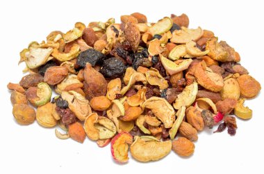 A pile of nuts and dried fruit on a white background. The nuts are mixed with dried fruit and some are in the form of apple slices