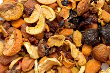 A bowl of mixed nuts and dried fruit. The nuts are almonds, cashews, and walnuts. The dried fruit is raisins and cranberries. The bowl is on a white surface