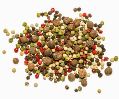 Beyaz arka planda bir yığın farklı renkli biber tohumu. Yığının içinde birçok farklı biber türü olduğu için bolluk ve çeşitlilik kavramı. Biberlerin renkleri canlı bir renk yaratır.