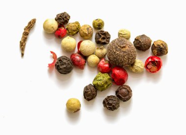A bunch of different colored peppers are scattered on a white background. The peppers are of various sizes and colors, including red, green, and yellow. Concept of abundance and variety