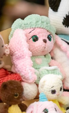 Yeşil elbiseli ve yeşil şapkalı doldurulmuş bir hayvan diğer doldurulmuş hayvanlarla aynı masada oturuyor.