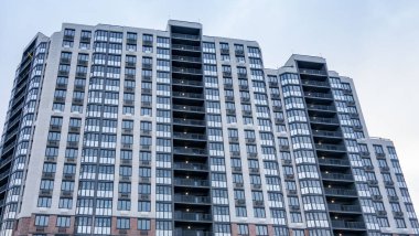 Birçok penceresi ve çok sayıda apartmanı olan yüksek bir bina. Bina çoğunlukla beyaz ve modern görünümlü.