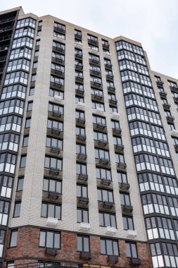 Bir sürü penceresi ve kliması olan yüksek bir bina. Bina çok yüksek ve bir sürü penceresi var.