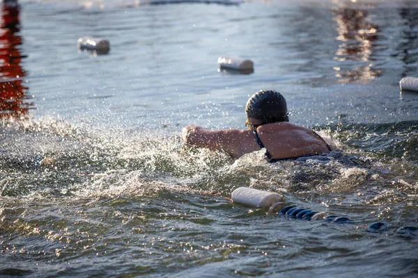 Havuzda yüzen bir kadın suyun içinde yüzebiliyor. Su sakin ve berrak.