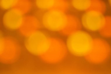 Bulanık turuncu bir arka plan ve küçük daireler. Daireler turuncu ve üst üste biniyor gibi görünüyor. Bu görüntünün hayali, ruhani bir kalitesi var.