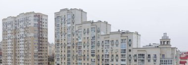 Bir sürü penceresi ve büyük bacası olan yüksek bir bina. Bina gri ve çok yüksek bir kulesi var.