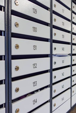 Üzerinde numaralar olan bir dizi beyaz ve siyah posta kutusu. Numaralar 123, 134, 143 ve 145.