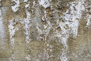 A wall with a lot of cracks and holes. The wall is made of concrete and has a rough texture