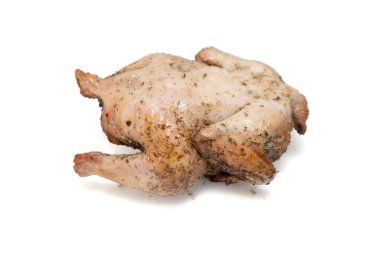 A whole chicken is sitting on a white background. The chicken is covered in spices and he is cooked