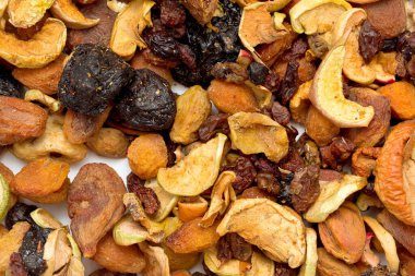 A bowl of mixed nuts and dried fruit. The nuts are almonds, cashews, and walnuts. The dried fruit is raisins, cranberries, and apricots. The bowl is on a white surface