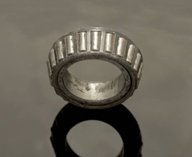 Yıpranmış, paslanmış ve kirli görünümlü bir alet. Teçhizat bir makinenin parçası ve iyi durumda değil.