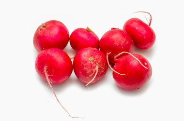 Kökleri görünen bir grup kırmızı turp. Turplar küçük ve yuvarlaktır ve sırayla dizilmişlerdir.