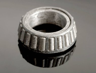 Yıpranmış, paslanmış ve kirli görünümlü bir alet. Teçhizat bir makinenin parçası ve iyi durumda değil.