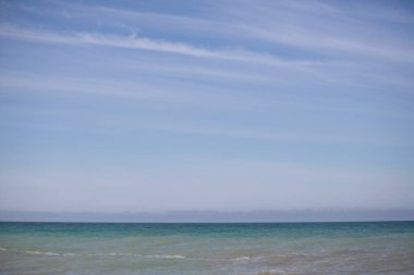 Blue sea and blue sky with white clouds. Seascape.