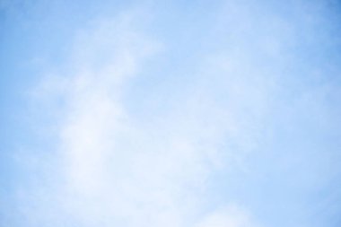 Beyaz bulutlu mavi bir gökyüzü. Gökyüzü berrak ve parlak, ve bulutlar gökyüzüne dağılmış.